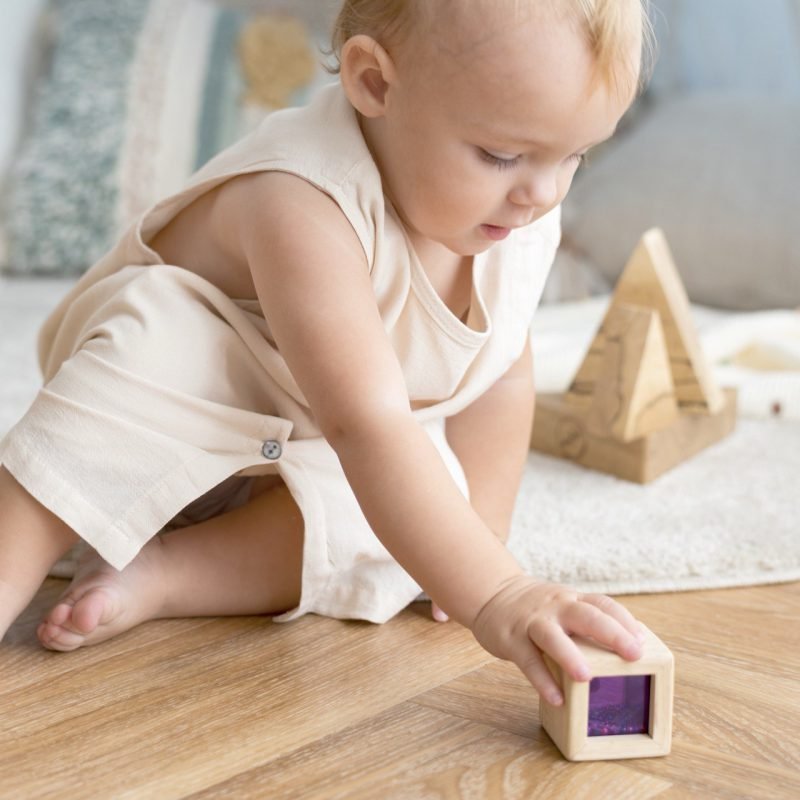 Baby van één jaar speelt met speelgoed – ontwikkelingsmijlpalen baby in actie