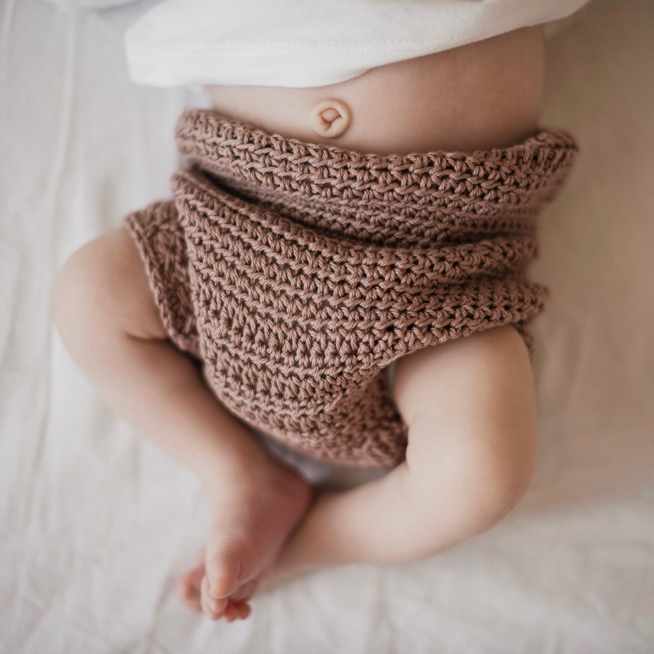 Een pasgeboren baby met een schone en droge navelstomp, cruciaal voor veilige navelverzorging pasgeboren baby.