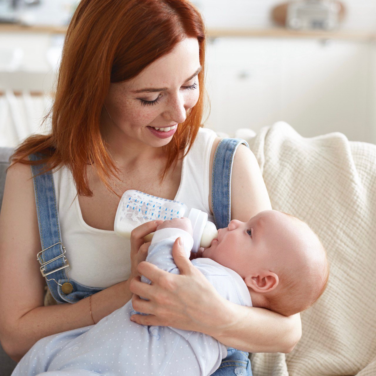 Moeder geeft baby fles met zuigelingenvoeding