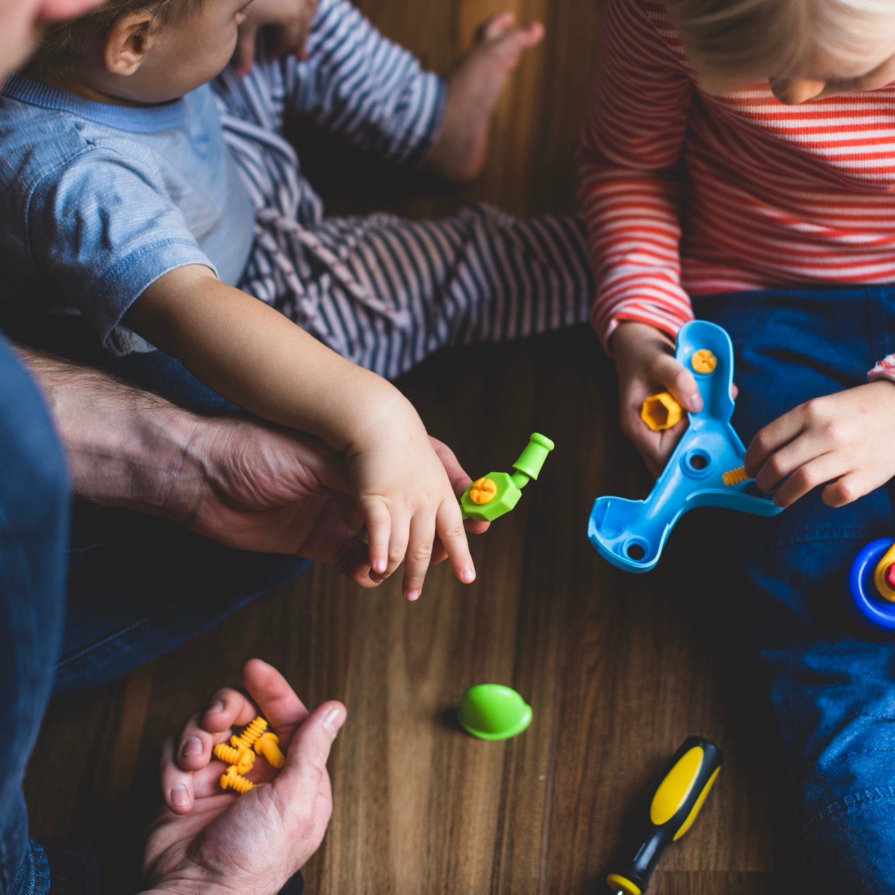 Kind speelt met speelgoed per leeftijdscategorie, passend bij de ontwikkelingsfase.