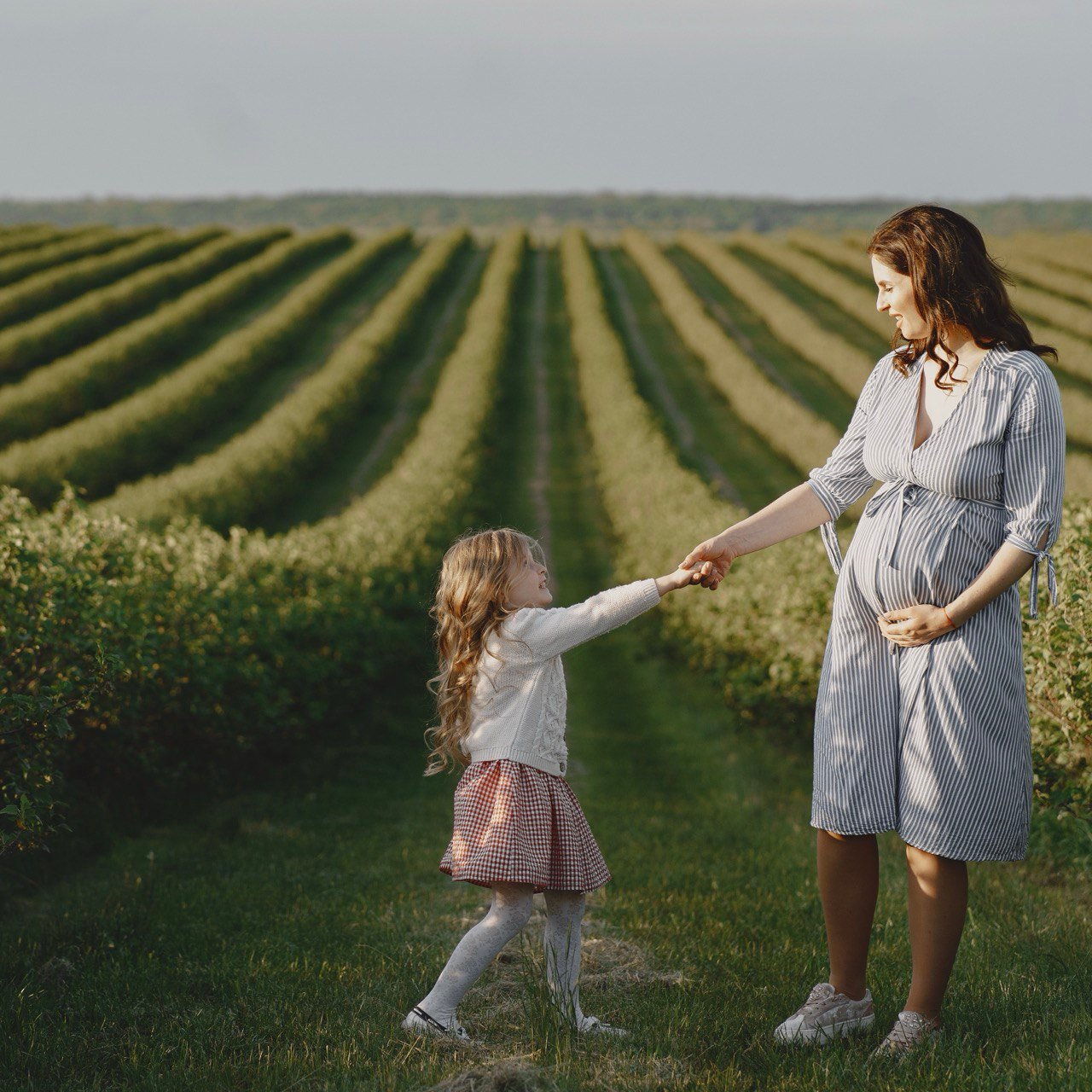 wangerschap en Duurzaam Moederschap: een Groene Moeder met haar dochter in een natuurlijke, landelijke omgeving.